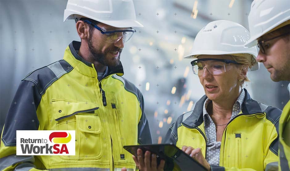 Two workers wearing hard hats looking at tablet